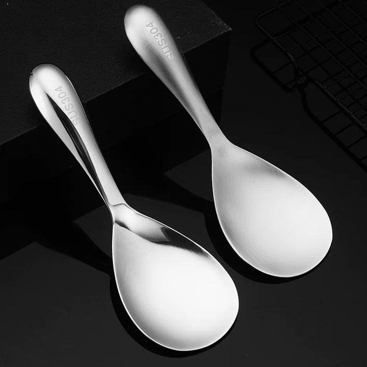 "Elegant och förtjockad non-stick rissked i rostfritt stål med ergonomiskt grepp, perfekt för kök och servering."