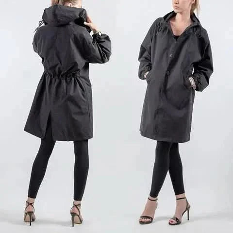 "Elegant och funktionell damregnkappa i modern oversized passform med stora knappar och stilfull huva, framifrån."