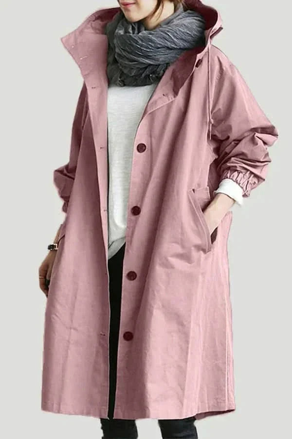 "Elegant och funktionell damregnkappa i modern oversized passform med stora knappar och stilfull huva, framifrån."