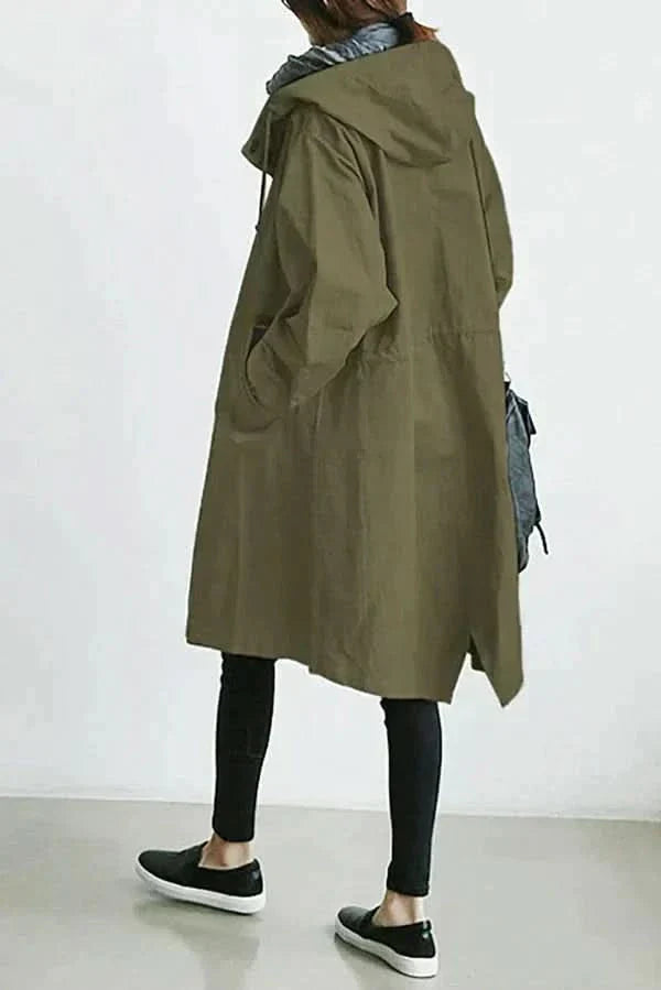 "Elegant och funktionell damregnkappa i modern oversized passform med stora knappar och stilfull huva, framifrån."