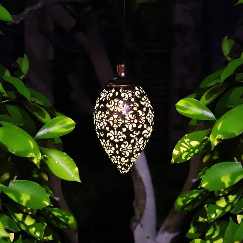 "Elegant soldriven vattentät trädgårdslampa i rostfritt stål, i dagsljus, med varmvit LED och robust metallhölje."