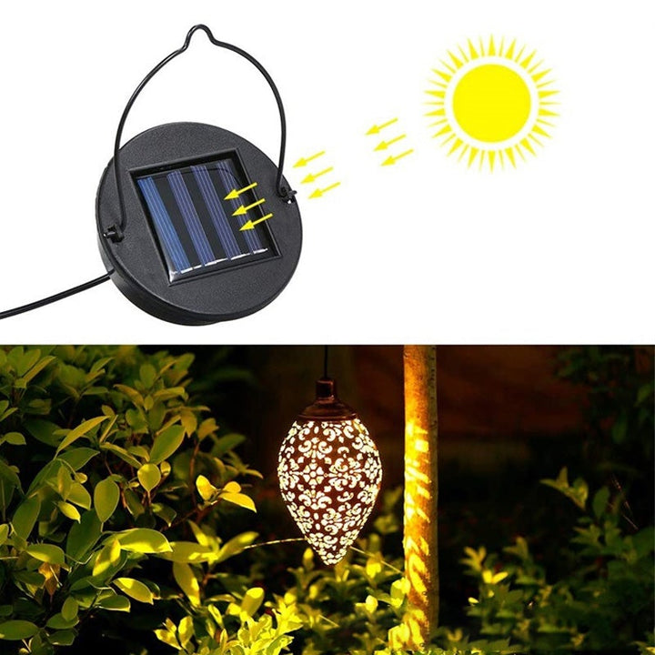 "Elegant soldriven vattentät trädgårdslampa i rostfritt stål, i dagsljus, med varmvit LED och robust metallhölje."