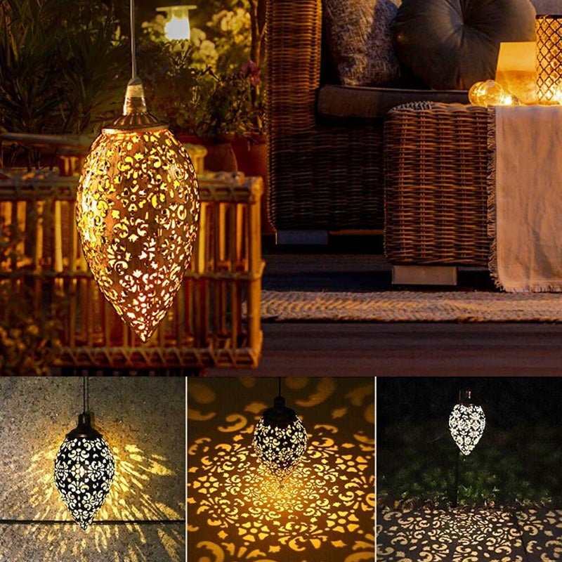 "Elegant soldriven vattentät trädgårdslampa i rostfritt stål, i dagsljus, med varmvit LED och robust metallhölje."