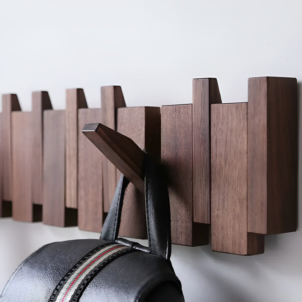 "Elegant väggorganisatör i bokträ och valnöt med magnetiska krokar och pianotangentdesign. Optimera och stilrent för hemmet."