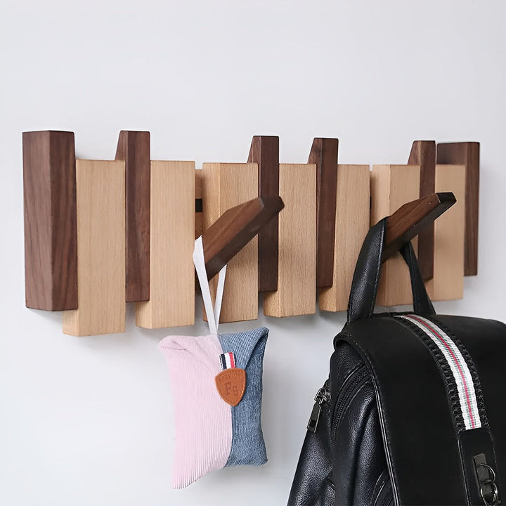 "Elegant väggorganisatör i bokträ och valnöt med magnetiska krokar och pianotangentdesign. Optimera och stilrent för hemmet."