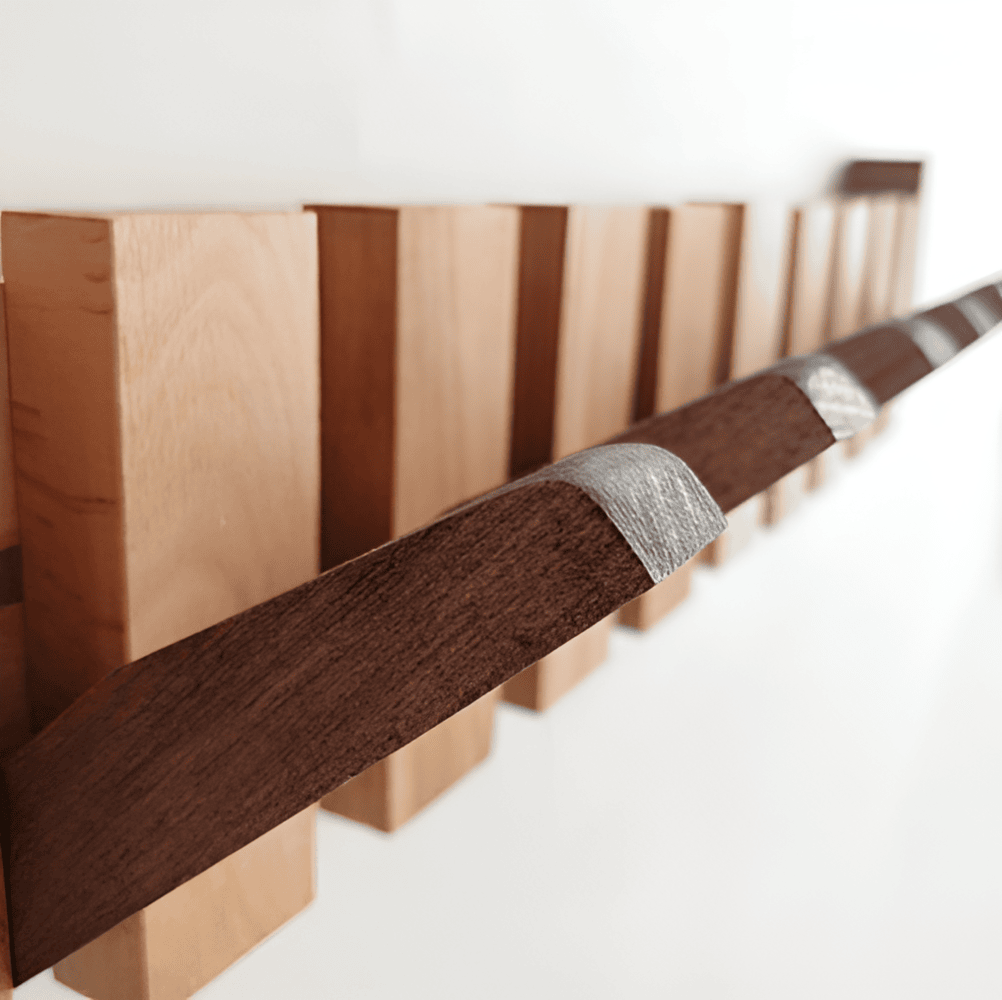"Elegant väggorganisatör i bokträ och valnöt med magnetiska krokar och pianotangentdesign. Optimera och stilrent för hemmet."