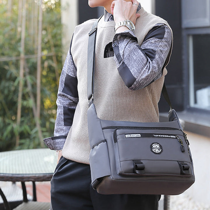 "Elegant, vattentät axelväska för män i slitstark oxfordduk, med flera fickor, perfekt för dagligt bruk och resor."