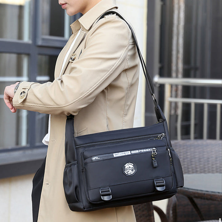 "Elegant, vattentät axelväska för män i slitstark oxfordduk, med flera fickor, perfekt för dagligt bruk och resor."