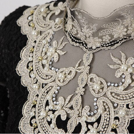 Modeblus i vit spets med fina detaljer och mesh, ger en sofistikerad look