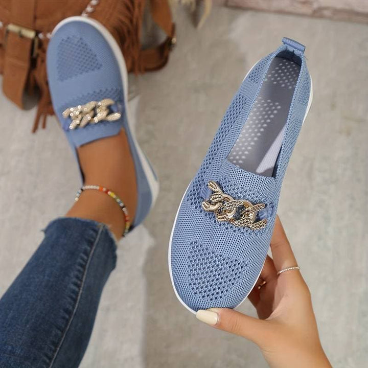 "Eleganta Samira Slip-On Sneakers med guld kedja, rosa färg, andningsbart material och vit sula, sidovy."