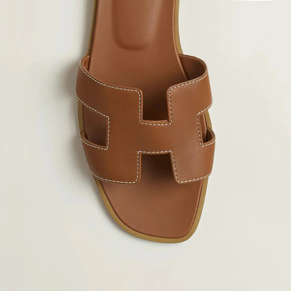 "Eleganta slip-on sandaler för kvinnor i stilrent H-mönster, platta med chic design, idealiska för sommardagar."