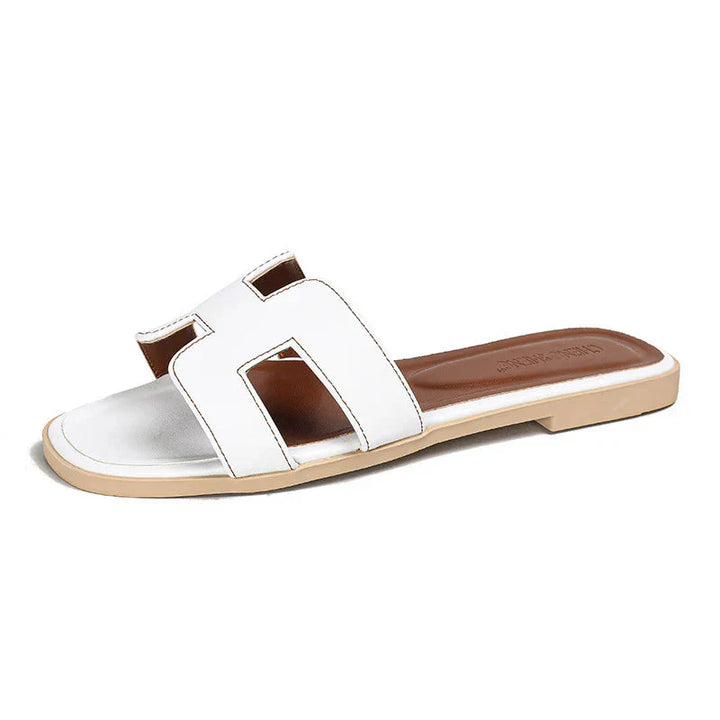 "Eleganta slip-on sandaler för kvinnor i stilrent H-mönster, platta med chic design, idealiska för sommardagar."