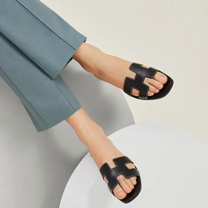 "Eleganta slip-on sandaler för kvinnor i stilrent H-mönster, platta med chic design, idealiska för sommardagar."