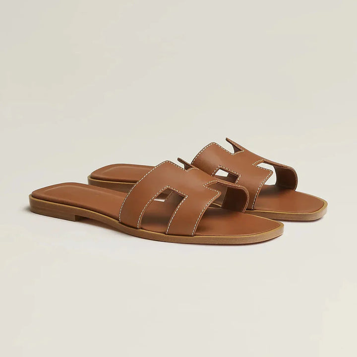 "Eleganta slip-on sandaler för kvinnor i stilrent H-mönster, platta med chic design, idealiska för sommardagar."