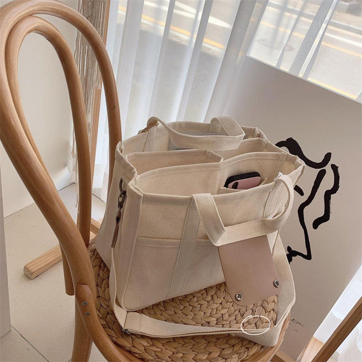 "Enfärgad dam tygkasse i robust canvas, med breda handtag och stor kapacitet. Perfekt som chic och hållbar väska."
