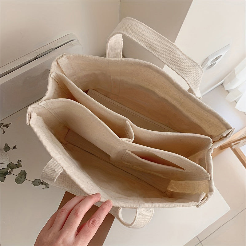 "Enfärgad dam tygkasse i robust canvas, med breda handtag och stor kapacitet. Perfekt som chic och hållbar väska."