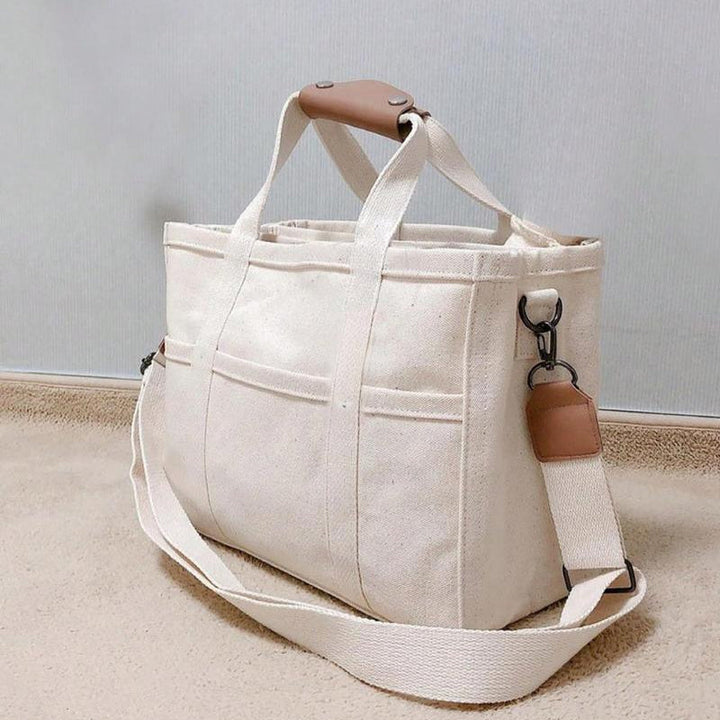 "Enfärgad dam tygkasse i robust canvas, med breda handtag och stor kapacitet. Perfekt som chic och hållbar väska."