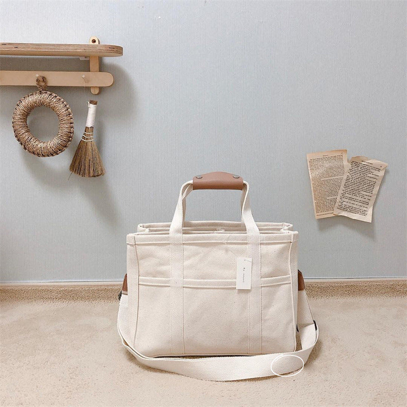 "Enfärgad dam tygkasse i robust canvas, med breda handtag och stor kapacitet. Perfekt som chic och hållbar väska."
