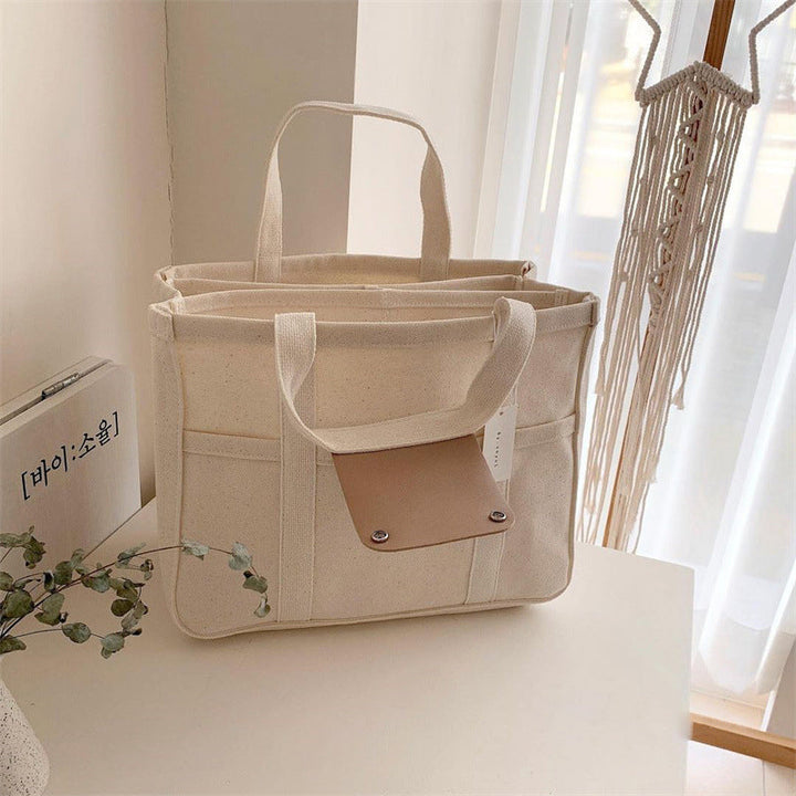"Enfärgad dam tygkasse i robust canvas, med breda handtag och stor kapacitet. Perfekt som chic och hållbar väska."