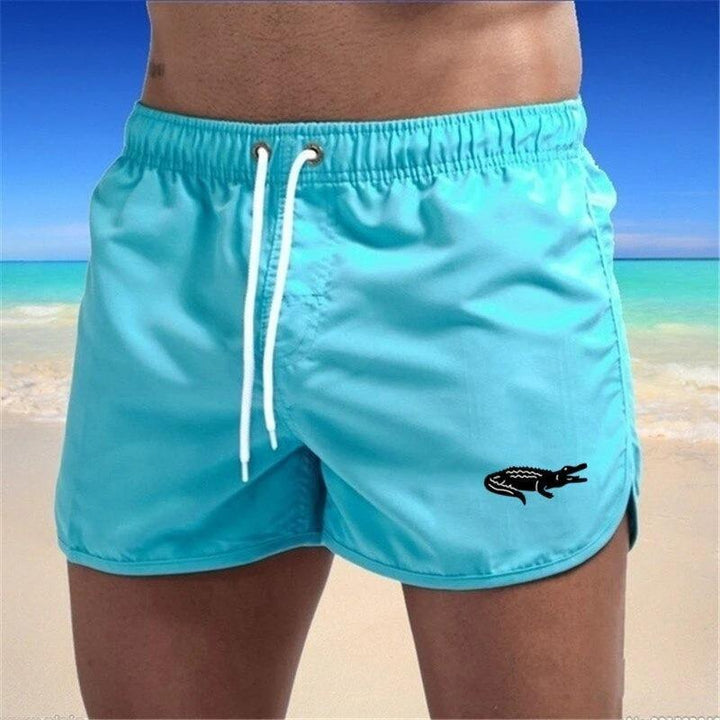 "Enfärgade herr badshorts med krokodilmönster i polyester, perfekt för sommar, tillgängliga i flera färger."