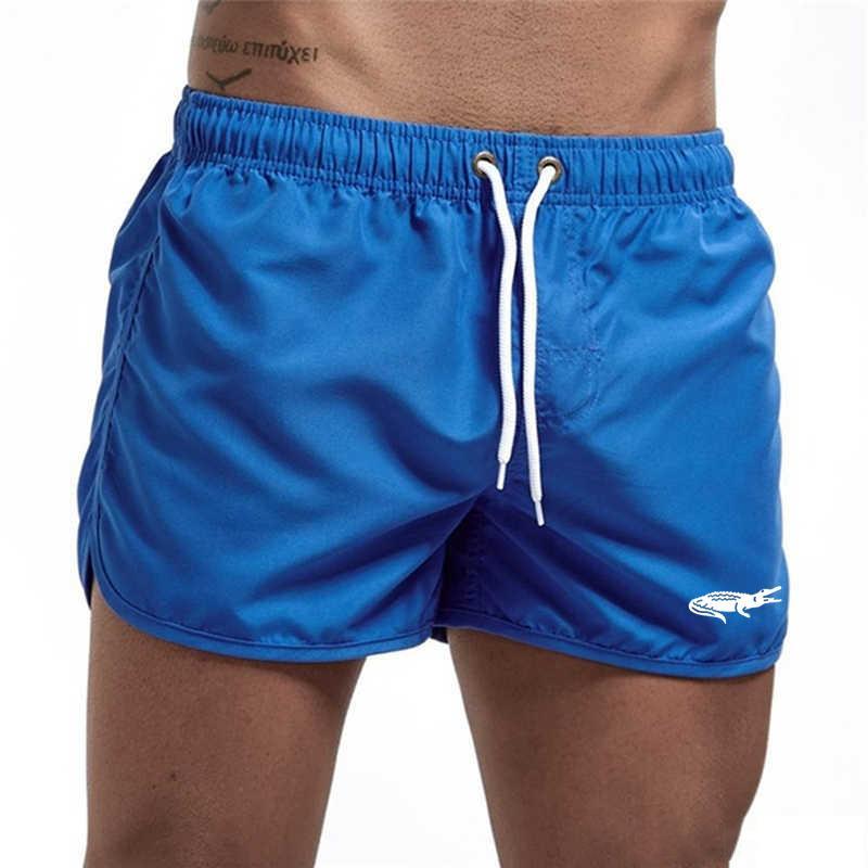 "Enfärgade herr badshorts med krokodilmönster i polyester, perfekt för sommar, tillgängliga i flera färger."