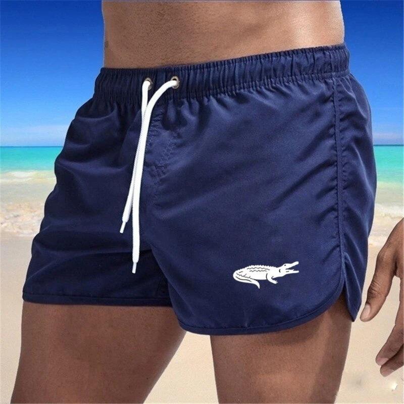 "Enfärgade herr badshorts med krokodilmönster i polyester, perfekt för sommar, tillgängliga i flera färger."