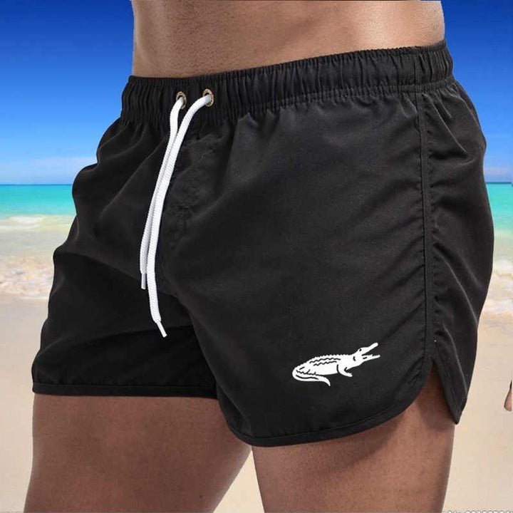 "Enfärgade herr badshorts med krokodilmönster i polyester, perfekt för sommar, tillgängliga i flera färger."
