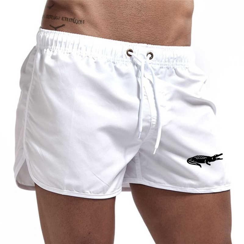 "Enfärgade herr badshorts med krokodilmönster i polyester, perfekt för sommar, tillgängliga i flera färger."
