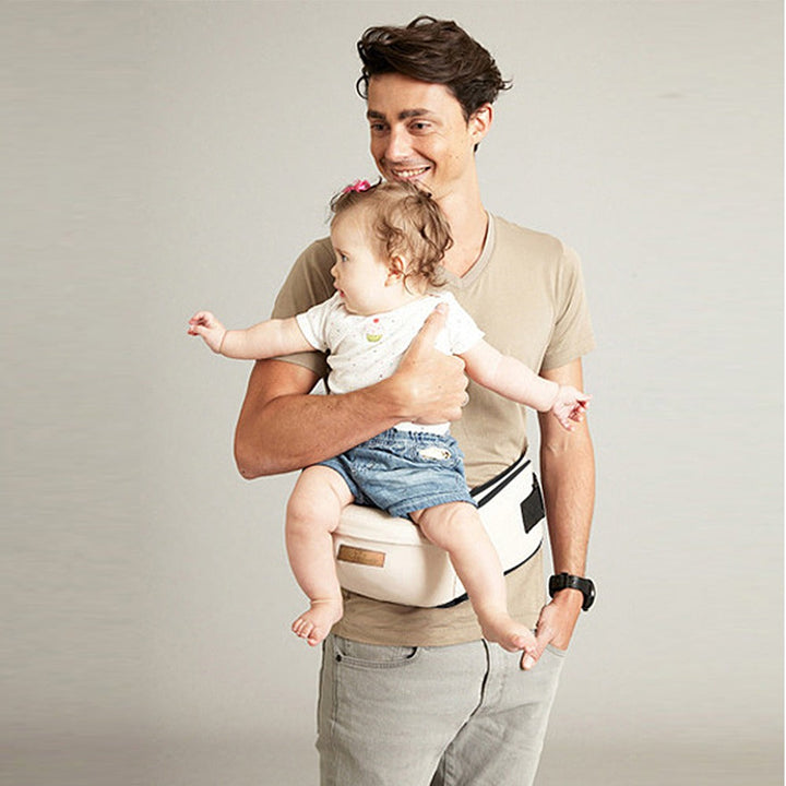 Ergonomisk babyhöftbärare i grått tyg, justerbart bälte, minskar ryggbelastning, flervändbara bärpositioner.