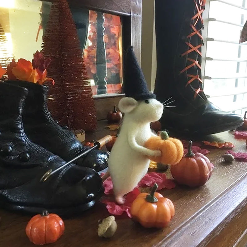 "Filtmus med orange pumpa och tematiska accessoarer för Halloween i ullfilt, idealisk som festlig hemdekoration."