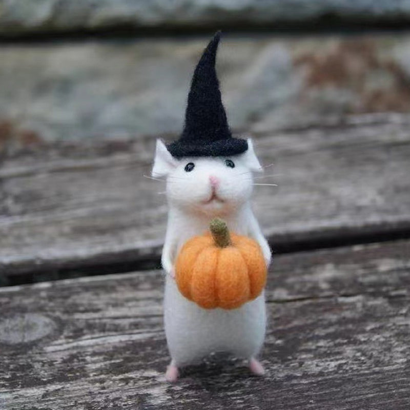 "Filtmus med orange pumpa och tematiska accessoarer för Halloween i ullfilt, idealisk som festlig hemdekoration."