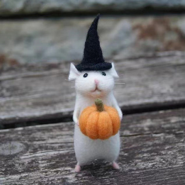 "Filtmus med orange pumpa och tematiska accessoarer för Halloween i ullfilt, idealisk som festlig hemdekoration."