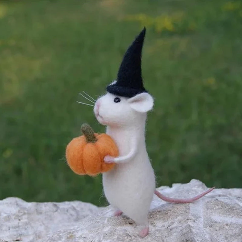 "Filtmus med orange pumpa och tematiska accessoarer för Halloween i ullfilt, idealisk som festlig hemdekoration."