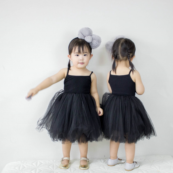 Barnklänning i lila tyll och paljetter, presenterad på en docka för att visa passformen.