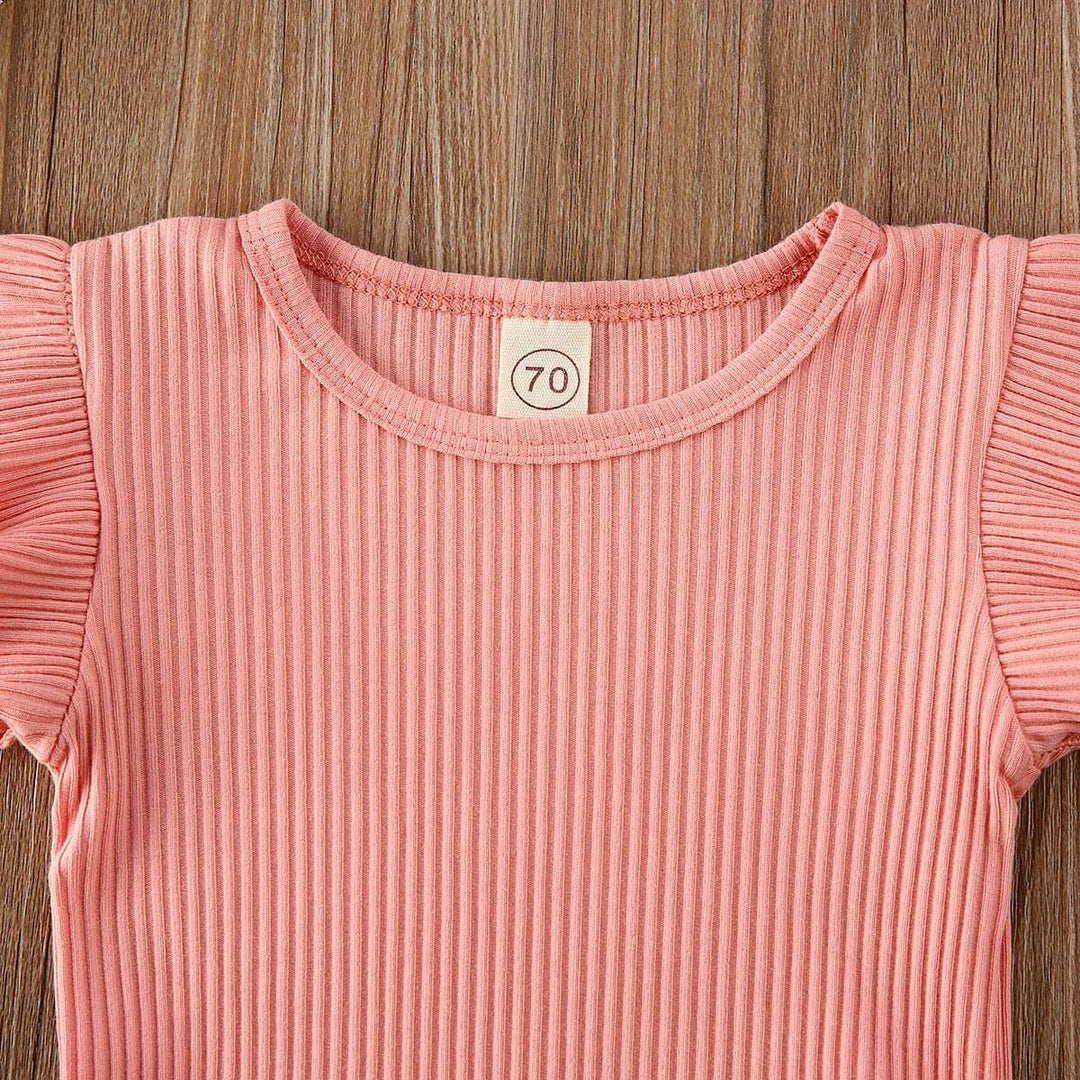 Närbild på det mjuka, stretchiga pannbandet som matchar flicks onesie-setet