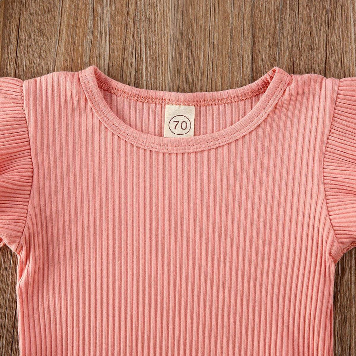 Närbild på det mjuka, stretchiga pannbandet som matchar flicks onesie-setet