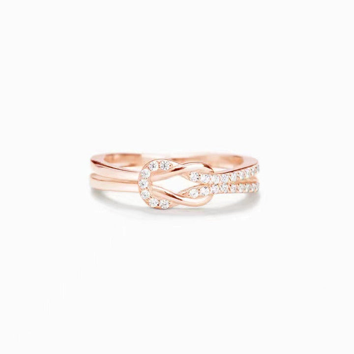 "Glänsande länkad ring i silver och roseguld, symbol för evigt band. Elegant, tidlös design, perfekt accessoar."