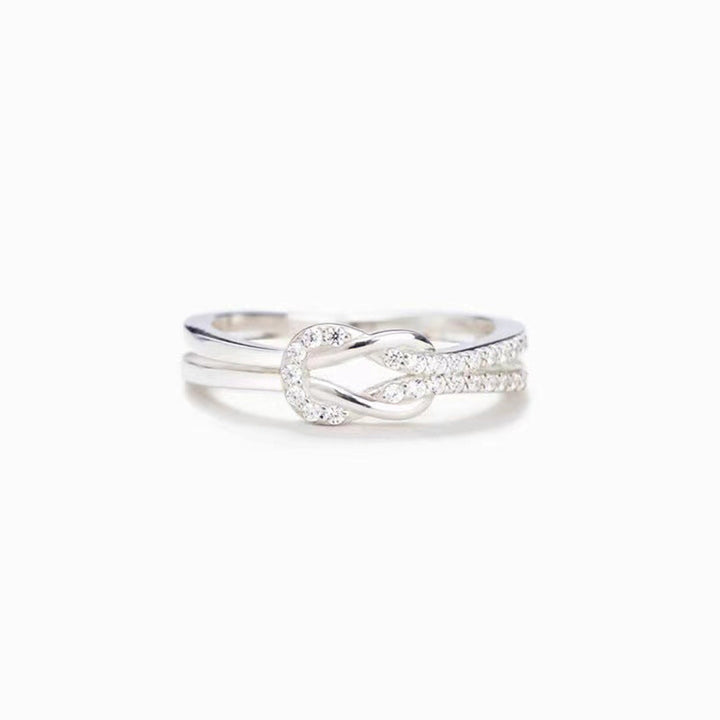 "Glänsande länkad ring i silver och roseguld, symbol för evigt band. Elegant, tidlös design, perfekt accessoar."