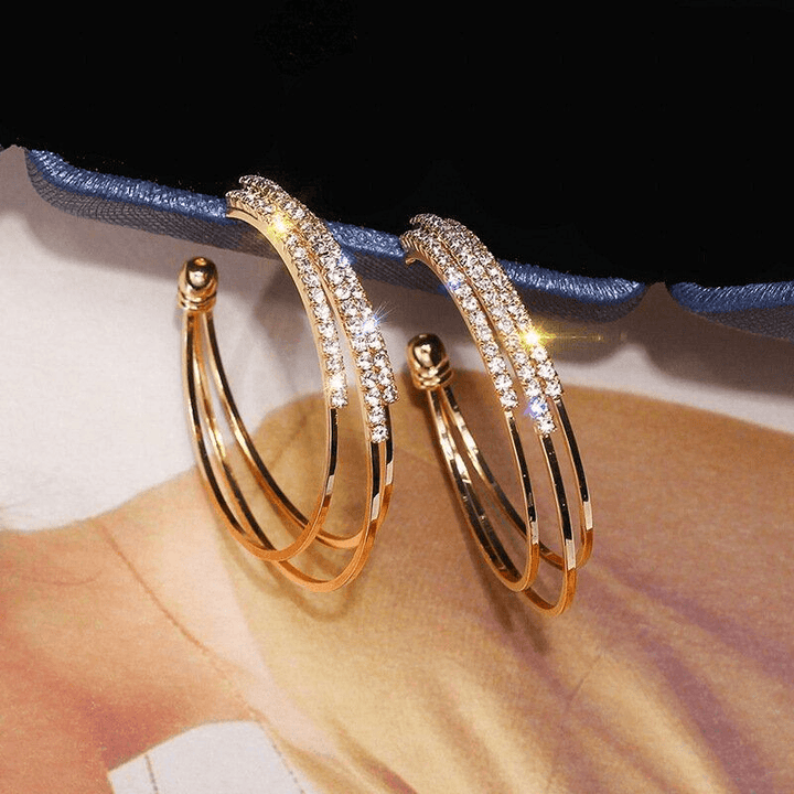 "Glänsande ringörhängen i guld och silver för kvinnor, elegant design, perfekt för både vardag och fest."