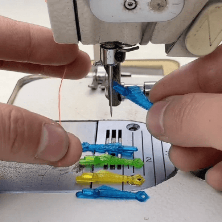 Grön fiskformad nålträdare av plast för symaskiner, enkel trädning, slitstark och kompatibel med äldre och nya maskiner.