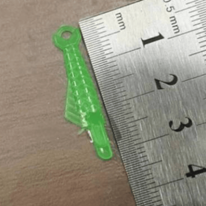 Grön fiskformad nålträdare av plast för symaskiner, enkel trädning, slitstark och kompatibel med äldre och nya maskiner.