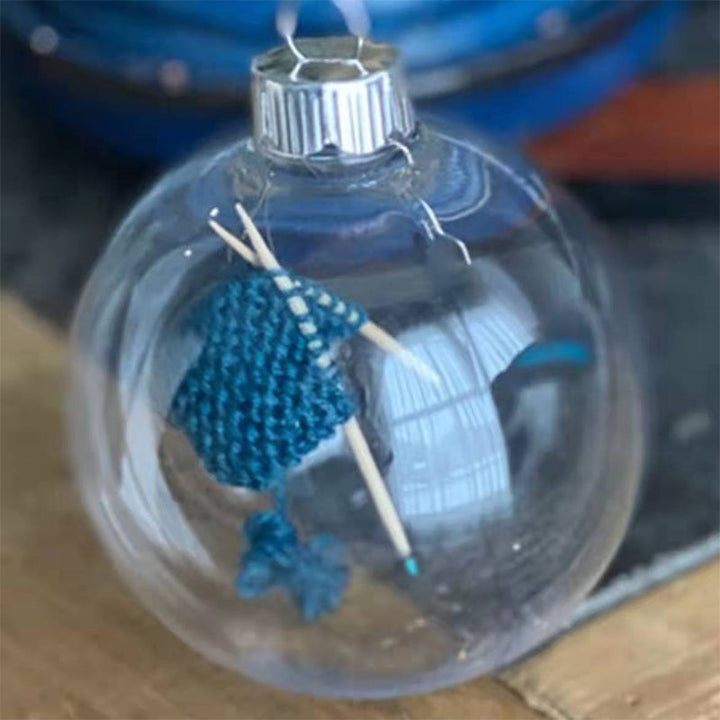 "Handgjord stickning juldekoration i glas, med akrylkula och charmig stickscen, perfekt för hem- och trädgårdsinredning."