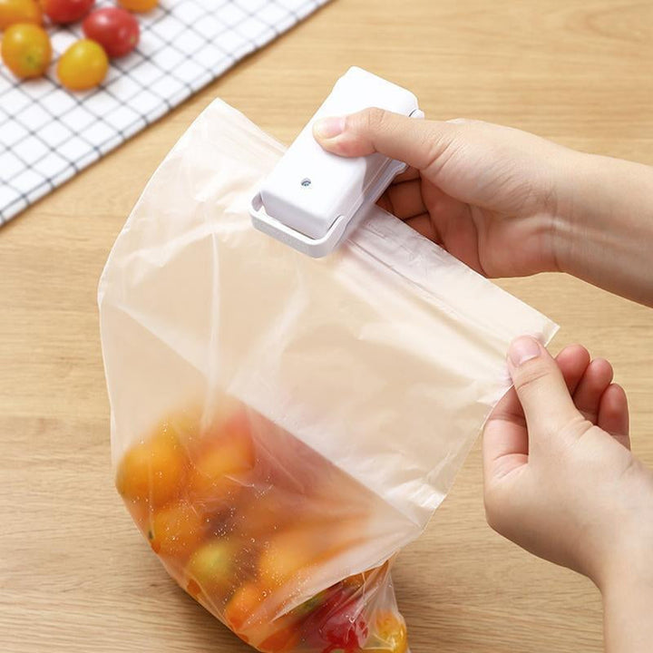 "Handhållen värmepåsförseglare för kök, kompakt och batteridriven med säkerhetsklämma, ideal för försegling av plastpåsar."