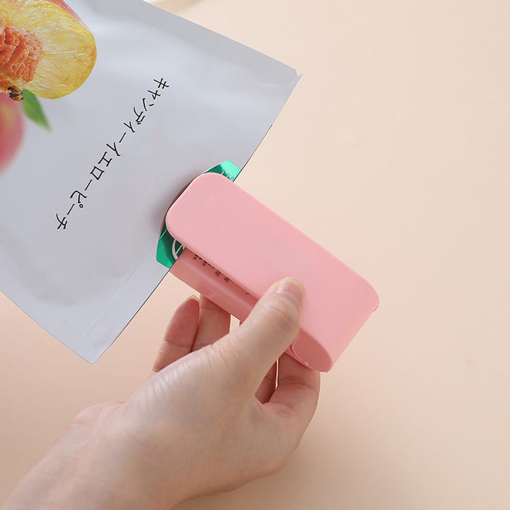 "Handhållen värmepåsförseglare för kök, kompakt och batteridriven med säkerhetsklämma, ideal för försegling av plastpåsar."