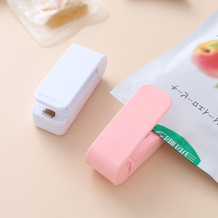 "Handhållen värmepåsförseglare för kök, kompakt och batteridriven med säkerhetsklämma, ideal för försegling av plastpåsar."
