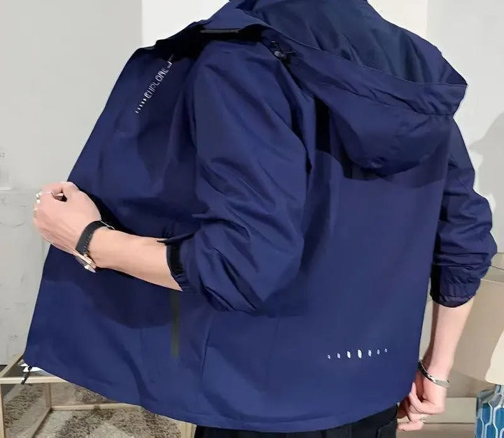 Outdoormiljö, man bär en Herr lättvikts regnjacka vid sjön, vindskydd