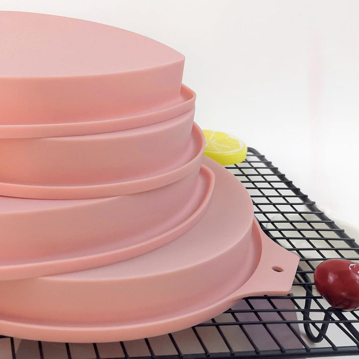 Hjärtformade silikon tårtformar i rosa och blå, perfekt för regnbågstårtor. Flexibla för enkel tårtuttagning.