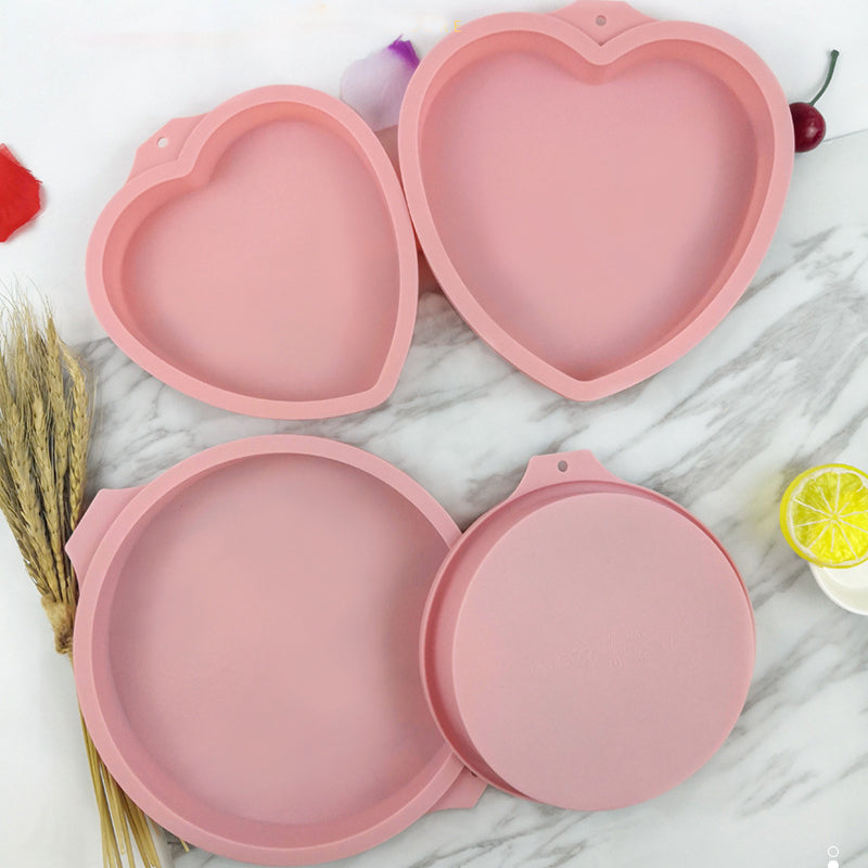 Hjärtformade silikon tårtformar i rosa och blå, perfekt för regnbågstårtor. Flexibla för enkel tårtuttagning.