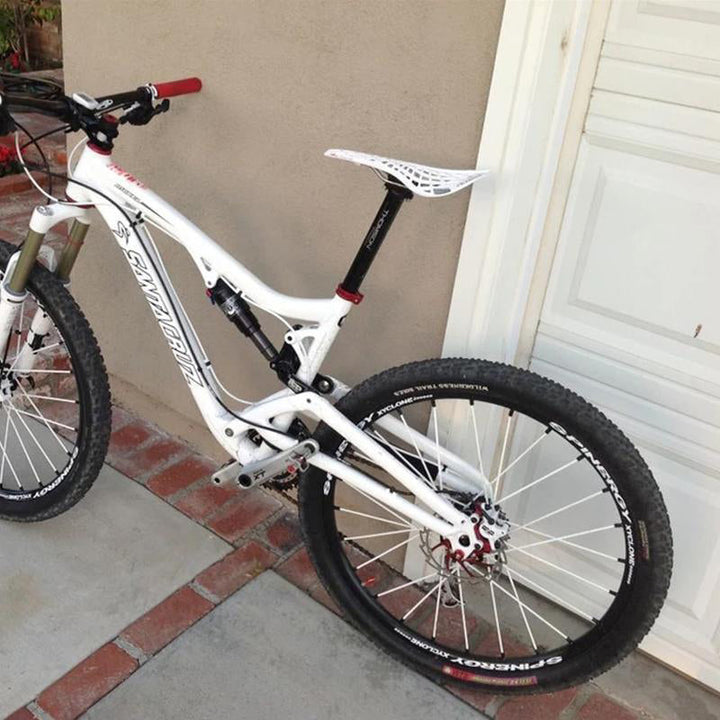 "Inbyggd cykelsadel i svart med andningsbar design och 69 ventilationshål för ökad komfort och minskad svettning."