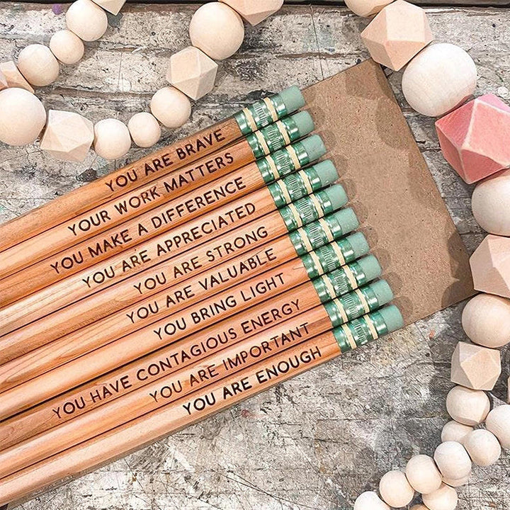 "Inspirerande affirmationspennor i trä, färgglada med motiv och positiva budskap, 10-pack till hemmet eller kontoret."